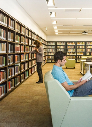 Photograph of two students in the library at the stacks