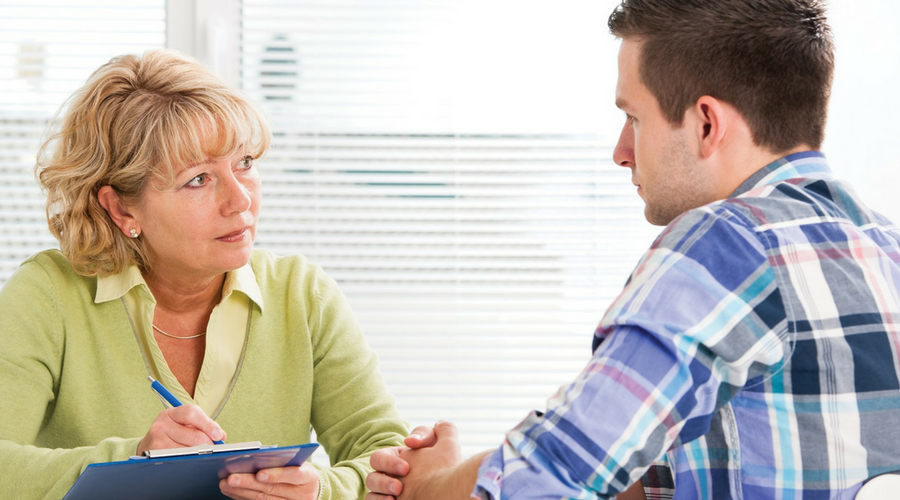 Image of woman listening to man talking in therapy-like session