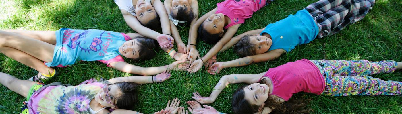 Photograph of campers laying in a circle