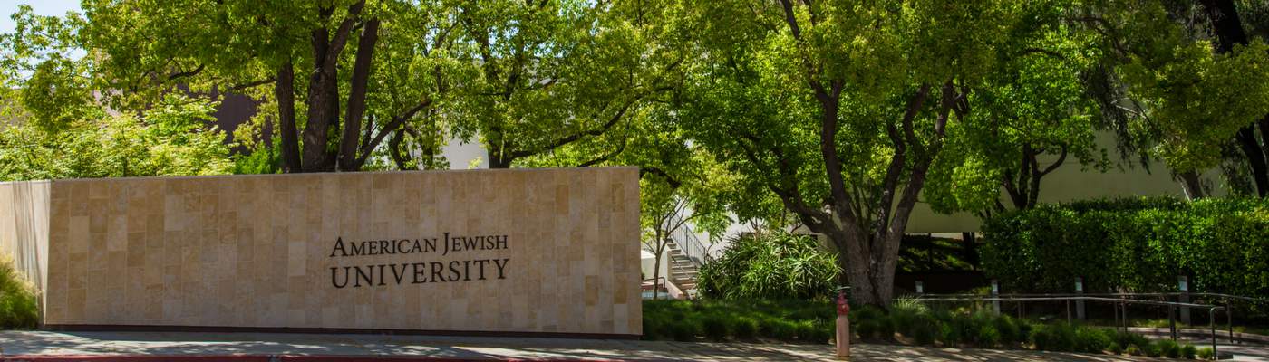 Photograph of campus sign and trees