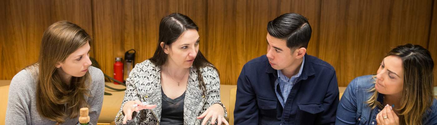 Photograph of three women and one man networking