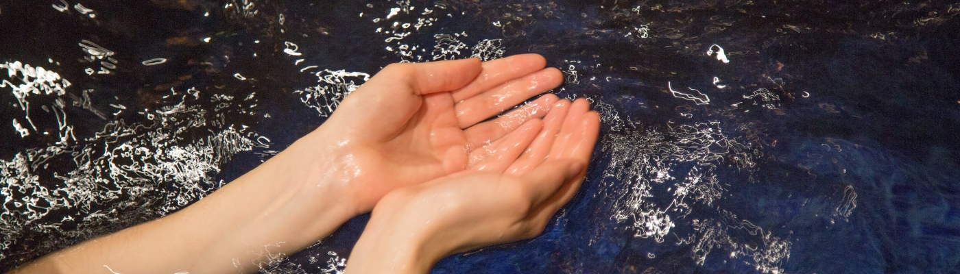 Photo of hands in the water of mikveh