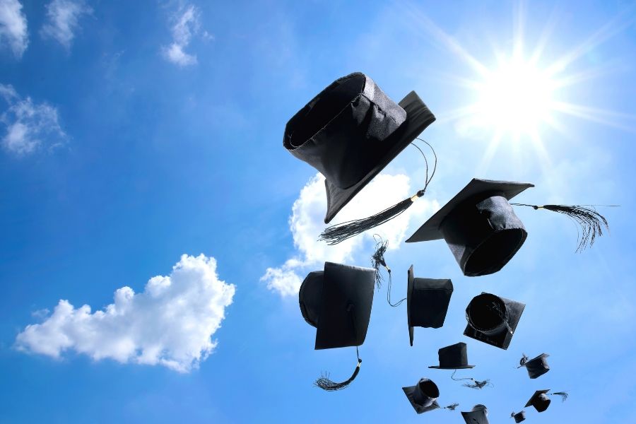 Image of graduation caps thrown up in the air