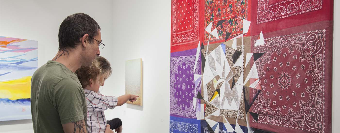 Photo of man and child looking at exhibit art