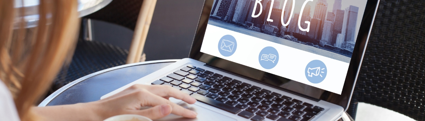 Photo of woman typing into laptop with word BLOG on the screen