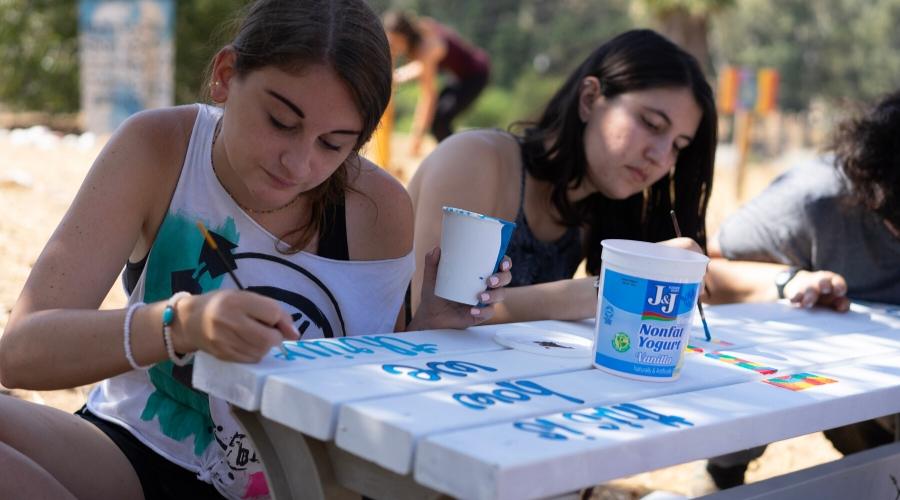 BCIers painting a bench outdoors