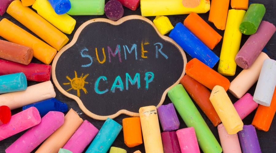 a pile of multicolored chalk that spells out Summer Camp