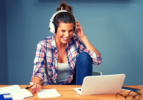 woman wearing headphones on computer