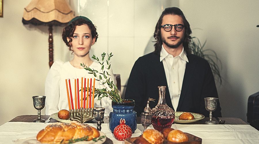 an ultra-orthodox couple sitting at their shabbat table