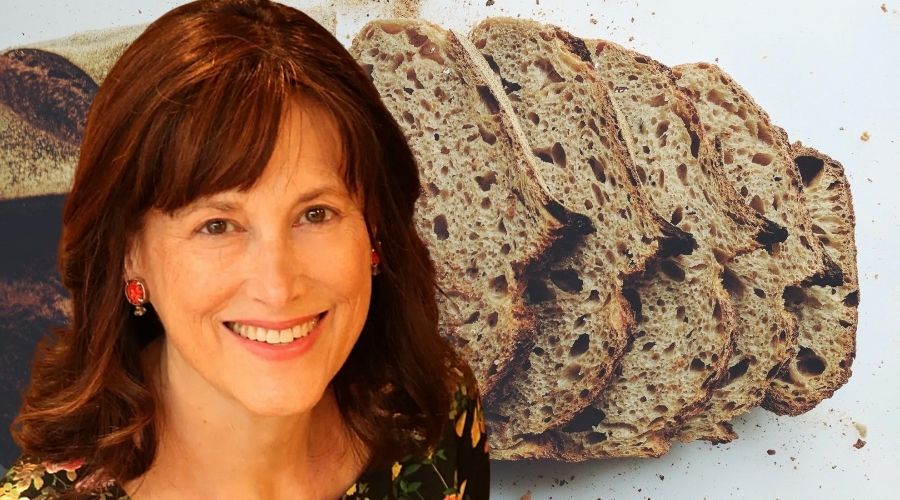 Debby Segura headshot in front of a loaf of sourdough bread