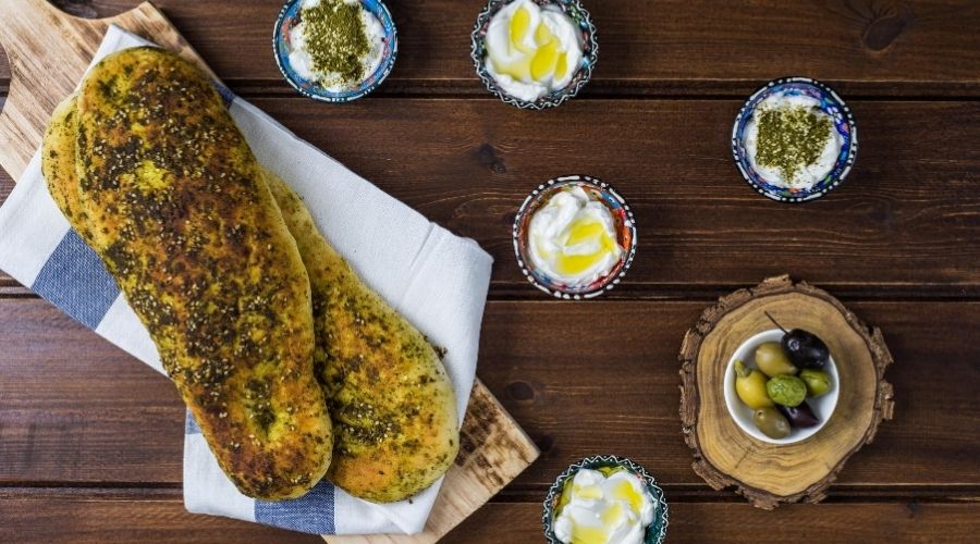za'atar-inspired table with bread loaf and dipping sauces