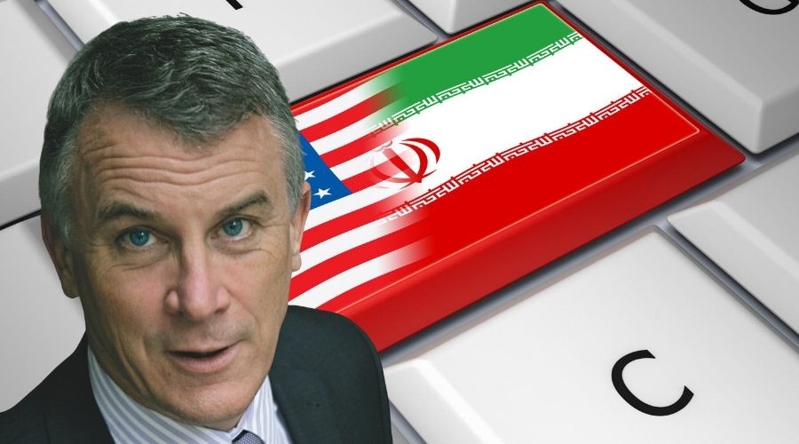 Michael Doran in front of a keyboard with the Iranian and US flags