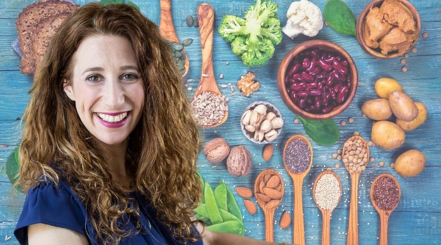 Ori Shavit in front of a colorful table of vegan foods and ingredients