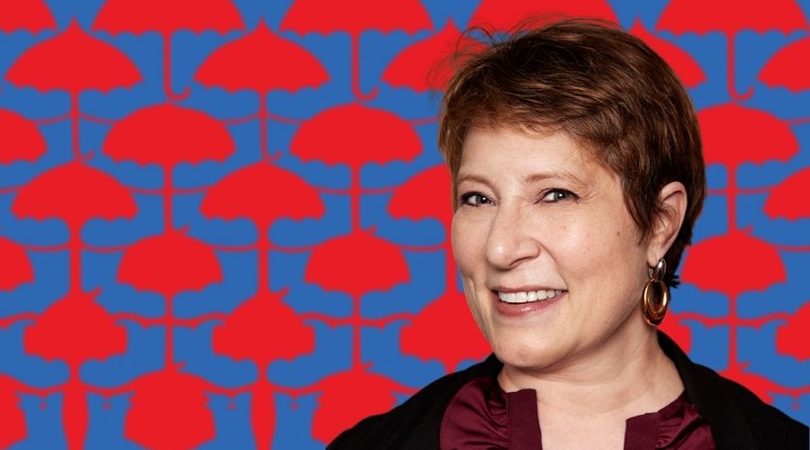 Amy Herman in front of a design of red umbrellas turning into flowers