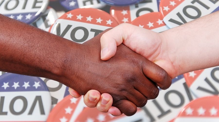 two hands shaking with a background of voter buttons