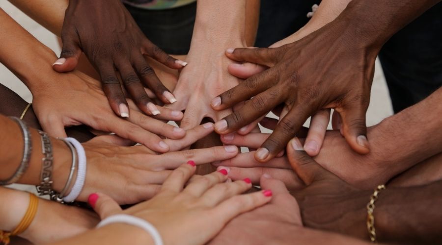 hands of different races piled on top of one another