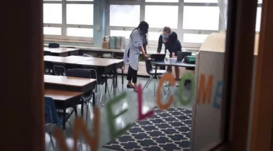 empty classroom with teachers in masks