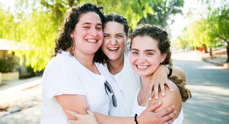 Photo of BCIers in Shabbat Whites Hugging