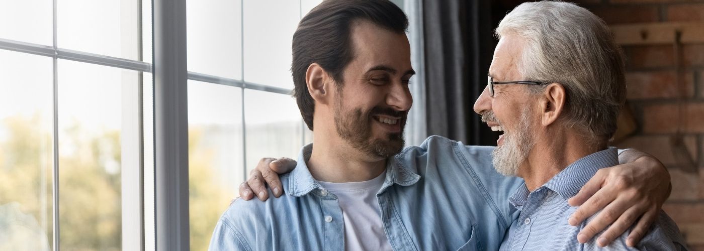 Image of Father and Adult Son Hugging and Smiling 