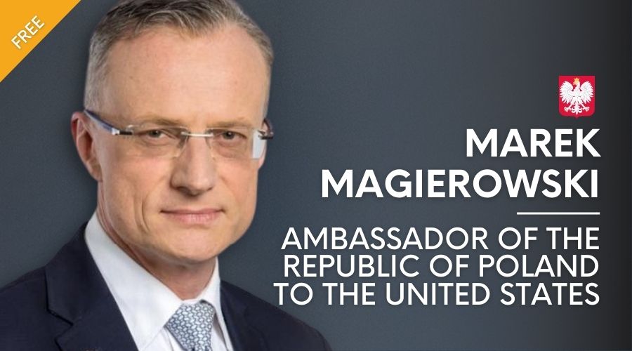 Ambassador Marek Magierowski with ad banner in background