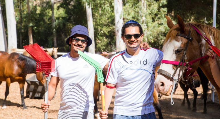 BcIers posing with rakes and horses