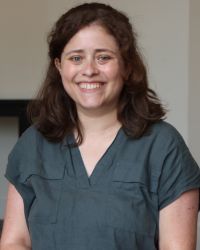 Headshot of Shira Muroff in v-neck gray shirt