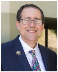 Headshot of Rabbi Artson in colorful tie and blue jacket