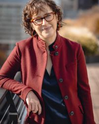 Shira Stutman in red jacket and red glasses
