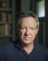 Headshot of Lawrence Wright in black polo shirt