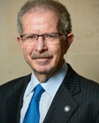 Headshot of Menachem Rosensaft in blue tie blue shirt and black jacket