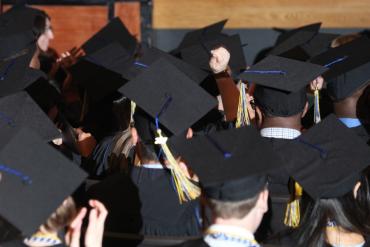 Photograph of the back of graduates in caps and gowns