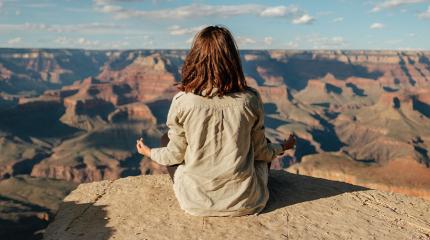 person meditating on a rock
