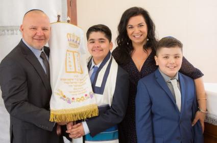 Photo of Mendoza Family, Mario, Sharon, Noah and Joshua, at Noah's Bar Mitzvah Holding the Torah